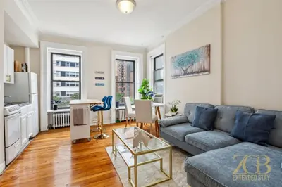 a living room with a couch and a table at Sweet and Cozy 1 Bedroom Apt in Lenox Hill in New York
