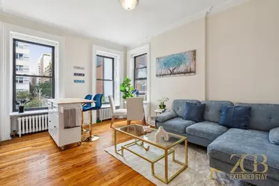 a living room with a blue couch and a table at Sweet and Cozy 1 Bedroom Apt in Lenox Hill in New York