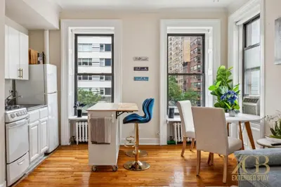 a kitchen with a table and chairs in a room at Sweet and Cozy 1 Bedroom Apt in Lenox Hill in New York
