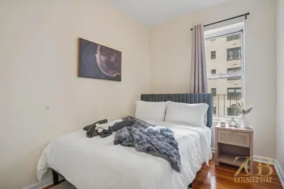 a bedroom with two beds and a window at Stylish 2-Bedroom Apartment in the Upper East Side in New York