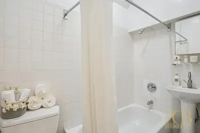 a bathroom with a shower curtain and a toilet and a sink at Stylish 2-Bedroom Apartment in the Upper East Side in New York