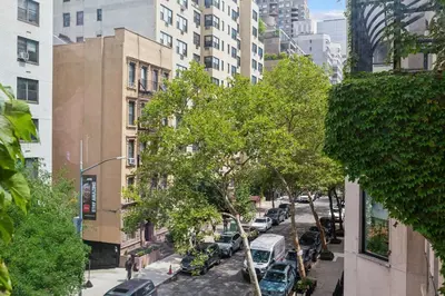 a city street with cars parked on the street at Stylish 2-Bedroom Apartment in the Upper East Side in New York