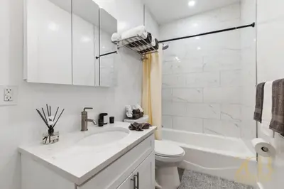 a white bathroom with a sink and a toilet at Chic 3BR 2BA West Village Apt with Private Oasis in New York
