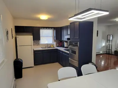 a kitchen with black cabinets and white appliances at Highland Estates, 5 Private Units for 1 Group! in Monticello
