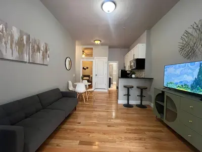 a living room with a couch and a flat screen tv at Cortland Manhattan Suites in New York