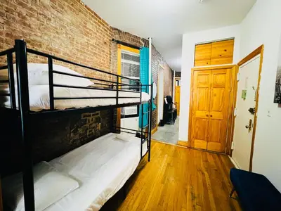 a room with two bunk beds and a brick wall at The Kensington on 44th in New York