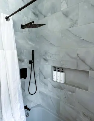 a white bathroom with a shower with a shower curtain at The Pink Haus