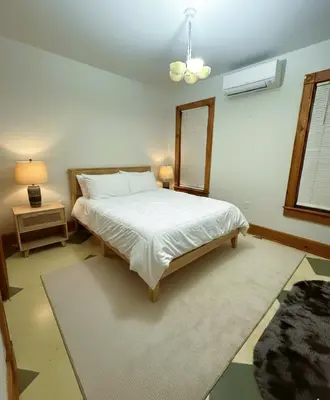 a bedroom with a white bed and a mirror at The Pink Haus