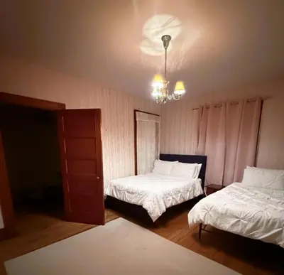 a bedroom with two beds and a chandelier at The Pink Haus