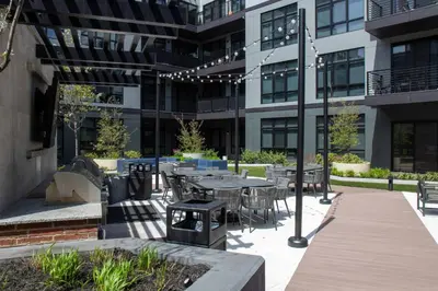 an outdoor patio with tables and chairs in front of a building at Luxury Stay Near NYC | Full Access to Amenities in Newark