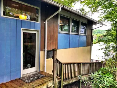 a small blue house with a dog in the doorway at Villa Adriana 4bdr 2 bath lake front dream home in Vernon