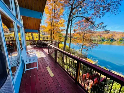 a porch with a bench and a view of a lake at Villa Adriana 4bdr 2 bath lake front dream home in Vernon