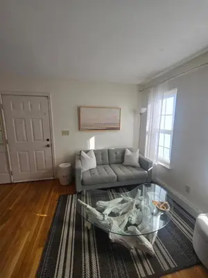 a living room with a couch and a glass table at Cozy Private Suite Near Train to NYC in Fairfield