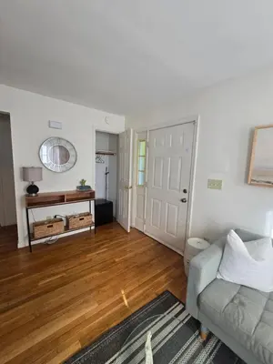 a living room with a couch and a wooden floor at Cozy Private Suite Near Train to NYC in Fairfield