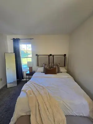 a bedroom with a large bed with a blanket on it at Cozy Private Suite Near Train to NYC in Fairfield