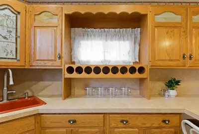 a kitchen with wooden cabinets and a window at All-American classic,18 min to Manhattan in Carlstadt