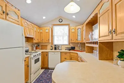 a kitchen with wooden cabinets and a white refrigerator at All-American classic,18 min to Manhattan in Carlstadt