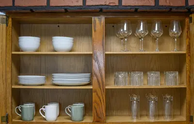 a wooden shelf with glasses and dishes on it at Classic American-style, 18 min to NYC in Carlstadt