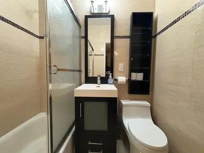 a bathroom with a sink and a toilet and a mirror at Signature by Times Square in New York
