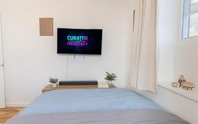 a bedroom with a bed and a tv on a wall at Comfy 2B Near LGA & Subway with Washer & Dryer in Corona