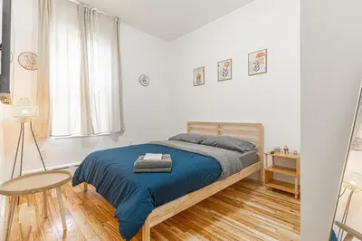 a white bedroom with a bed and a table at Comfy 2B Near LGA & Subway with Washer & Dryer in Corona