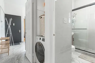 a bathroom with a washing machine in a room at Comfy 2B Near LGA & Subway with Washer & Dryer in Corona