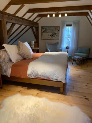 a bedroom with a large bed with white sheets at The Colrain Suite in Colrain