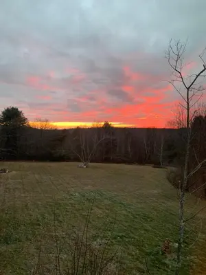 a field with a sunset in the background at The Colrain Suite in Colrain