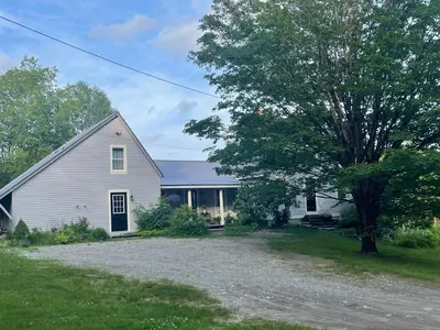 a white house with a tree and a driveway at The Colrain Suite in Colrain