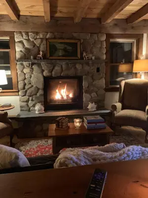 a fireplace in a living room with a stone wall at The Colrain Suite in Colrain