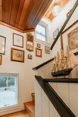 a staircase with a model ship on the wall at Creekfront Cabin Sauna & Hot Tub Hikers Hollow in Cuddebackville