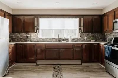 a kitchen with wooden cabinets and a window at Swan Pond Cabin Hot Tub & Firepit Retreat in Swan Lake