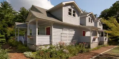 a white house with red doors at Catskill Rose Lodging & Dining in Mount Tremper