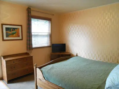 a bedroom with a bed and a dresser and a television at Catskill Rose Lodging & Dining in Mount Tremper