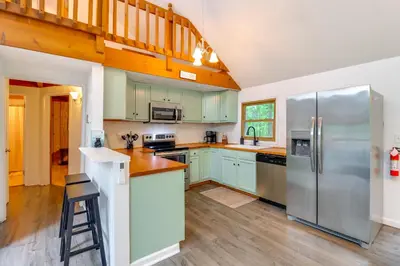 a kitchen with green cabinets and a stainless steel refrigerator at 1 Mi to Lake, Golf and Ski Access The Hideout Home! in Arlington