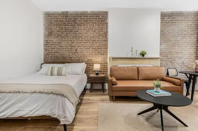 a bedroom with a bed and a couch at Time Square Apartment in New York