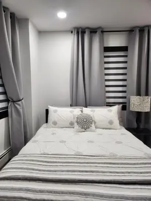 a bedroom with a large bed with gray curtains at Modern & Tranquil Apartment in Bogota