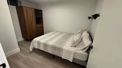 a small bedroom with a bed and a cabinet at Modern Townhouse in Historic Harlem in New York