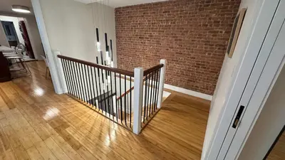 a hallway with a staircase with a brick wall at Modern Townhouse in Historic Harlem in New York