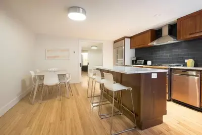 a kitchen with a counter and a table and chairs at Modern Townhouse in Historic Harlem in New York