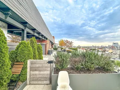 a white chair sitting on a balcony of a building at Penthouse in Greenpoint in Brooklyn