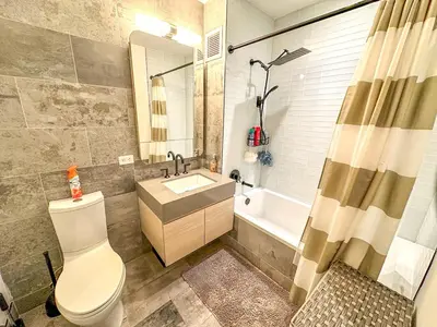 a bathroom with a toilet and a sink and a tub at Penthouse in Greenpoint in Brooklyn