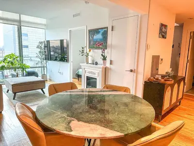 a living room with a glass table and chairs at Penthouse in Greenpoint in Brooklyn