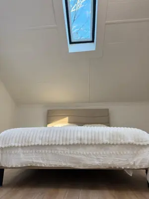 a white bed in a room with a window at King Cabin
