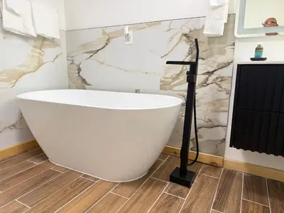 a white bath tub in a bathroom with marble walls at King Cabin