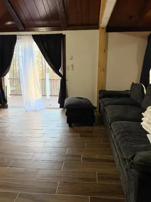 a living room with a couch and a wooden floor at King Cabin