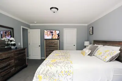 a bedroom with a bed and a tv on the wall at Oneonta Hideaway in Oneonta