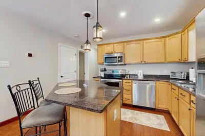 a kitchen with wooden cabinets and a counter top at Buckboard Haven in Dover