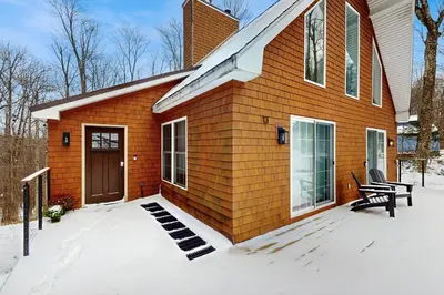 a small house in the snow with a bench at Buckboard Haven in Dover