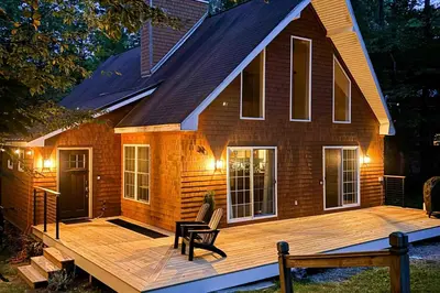 a house with a wooden deck in front of it at Buckboard Haven in Dover
